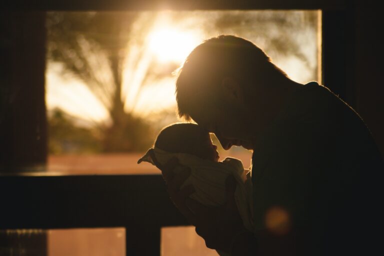 a man holding anew born baby, the wonders if life